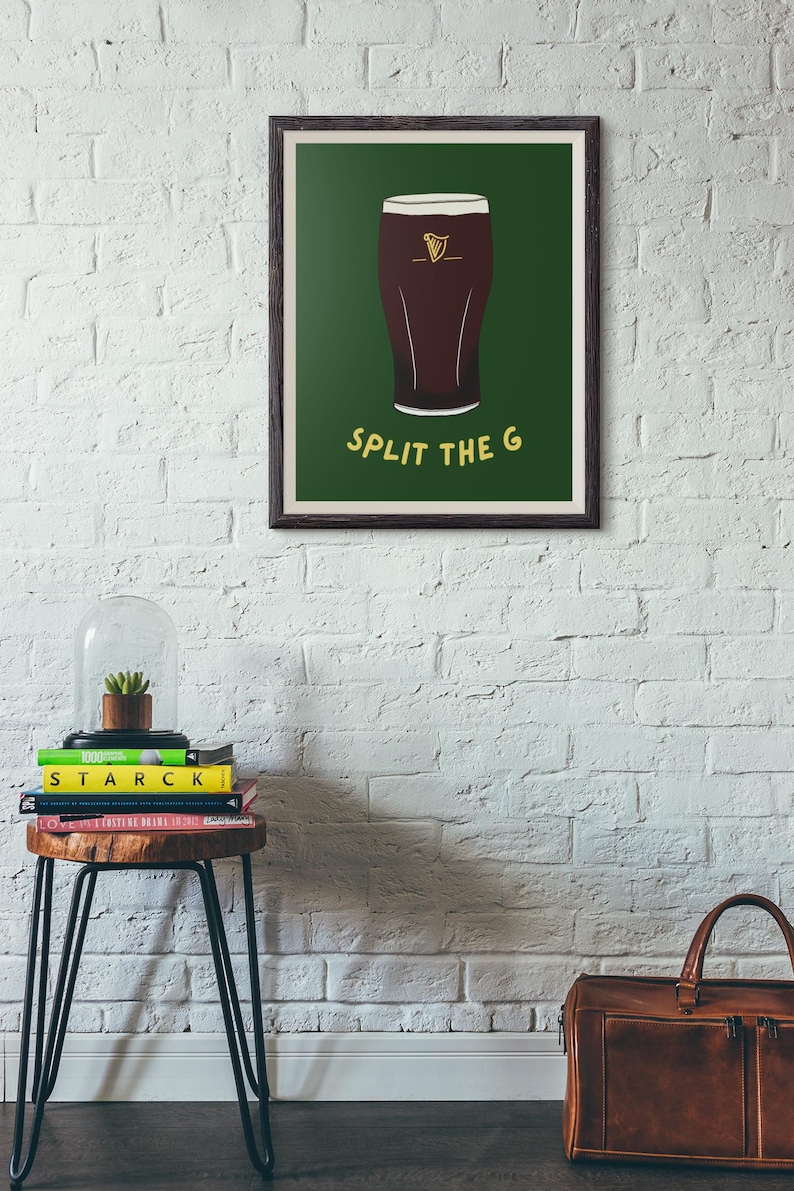 May include: A framed print with a green background and a cartoon illustration of a glass of Guinness beer. The text "SPLIT THE G" is printed in yellow below the glass.