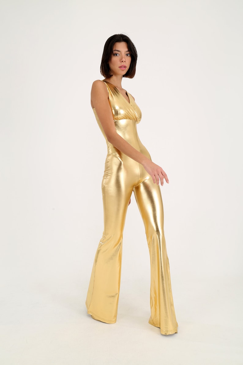 May include: A gold metallic jumpsuit with a V-neck and wide-leg pants.
