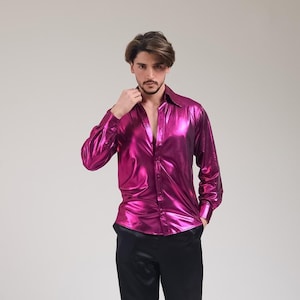 K&ouml;nnte beinhalten: Ein gl&auml;nzendes, fuchsiafarbenes Hemd mit Kn&ouml;pfen und langen &Auml;rmeln. Das Hemd hat einen metallischen Glanz und einen klassischen Kragen. Das Kleidungsst&uuml;ck wird mit einer schwarzen Hose kombiniert. Der Stoff des Hemdes scheint leicht und leicht gl&auml;nzend zu sein.