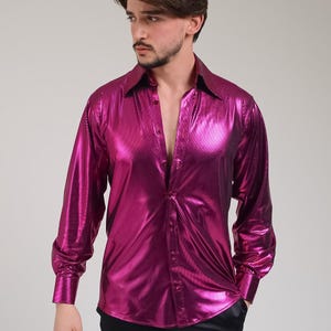 K&ouml;nnte beinhalten: Ein gl&auml;nzendes, magentafarbenes Langarmhemd mit Knopfleiste und klassischem Kragen. Das Hemd hat einen metallischen Glanz und besteht aus einem glatten, reflektierenden Stoff. Die Manschetten sind gekn&ouml;pft, und das Hemd ist oben aufgekn&ouml;pft.