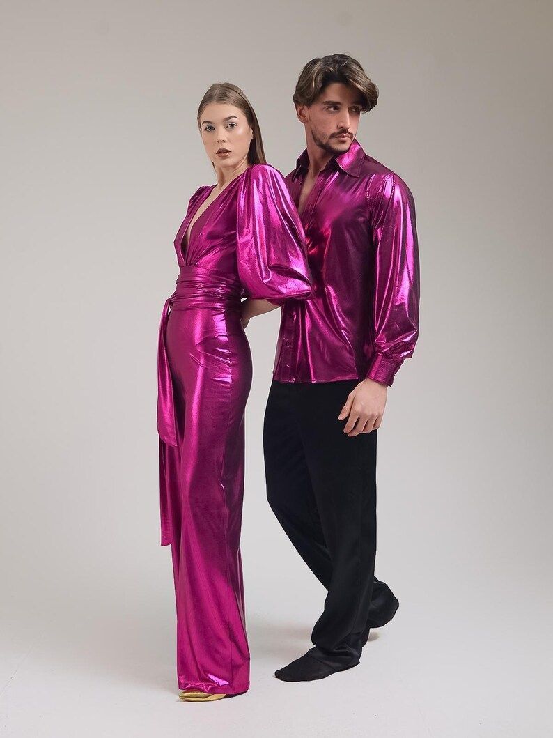 K&ouml;nnte beinhalten: Eine Frau in einem fuchsiafarbenen Overall mit Wickelbund und ein Mann in einem fuchsiafarbenen Hemd mit Kn&ouml;pfen und schwarzer Hose. Die Kleidung hat einen metallischen Glanz, was auf Party- oder formelle Kleidung hindeutet.