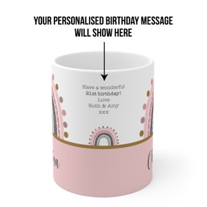Op de afbeelding: Een witte keramische mok met een roze en gouden ontwerp met regenbogen en stippen. De mok heeft een gepersonaliseerd verjaardagsbericht met de tekst "Have a wonderful 21st birthday! Love Ruth & Amy XXX".