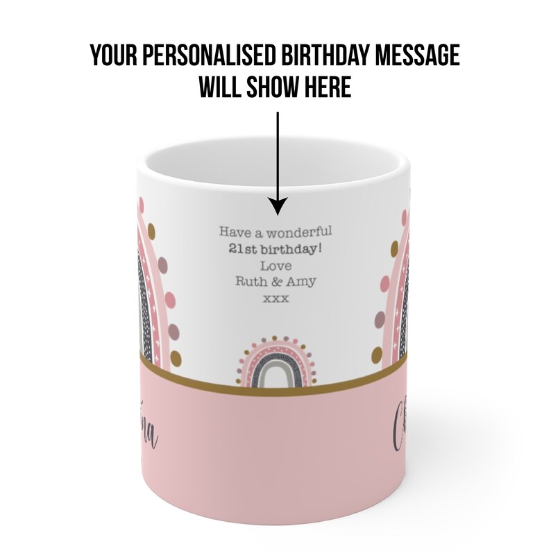 Op de afbeelding: Een witte keramische mok met een roze en gouden ontwerp met regenbogen en stippen. De mok heeft een gepersonaliseerd verjaardagsbericht met de tekst "Have a wonderful 21st birthday! Love Ruth & Amy XXX".