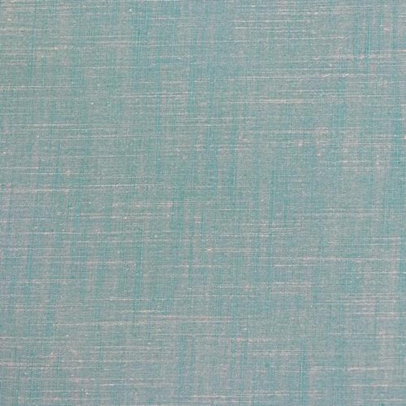 May include: A close-up of a light blue fabric with a subtle woven texture.