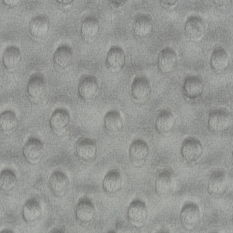 May include: Close-up of a gray textured fabric with a repeating pattern of small raised circles.