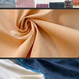 May include: Close-up of a peach-colored fabric with a subtle dotted pattern. The fabric is folded and draped, showcasing its texture. The text "wildflower wovens" is printed on a blue label.