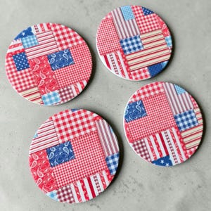 May include: Three circular coasters featuring a patchwork design of red, white, and blue fabric patterns. The prints include gingham checks, thin stripes, paisley motifs, and small stars, arranged in a quilt-like collage on each round surface.