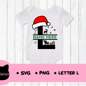 May include: White onesie with a black letter L design. The letter L is decorated with a red Santa hat, a reindeer, a sleigh, and presents. The text "NAME HERE" is written in green on a white banner.