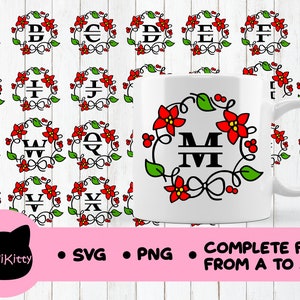May include: A white mug with a red and green floral wreath design featuring the letters "MIVI" in black. The mug is surrounded by a pattern of 26 wreaths, each with a different letter of the alphabet, in black and red.