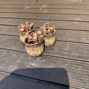 Peut inclure: Trois petits paniers tissés remplis de petits bâtonnets en bois. Les paniers sont bruns et ont une texture tissée naturelle. Les bâtonnets sont de couleur brun clair et sont disposés de manière aléatoire.