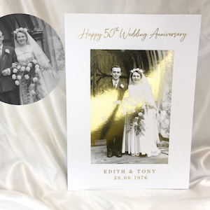 May include: A white card with a gold foil image of a couple and the text "Happy 50th Wedding Anniversary". The card also features a black and white photo of the couple and the names "EDITH & TONY" and the date "29.09.1976".