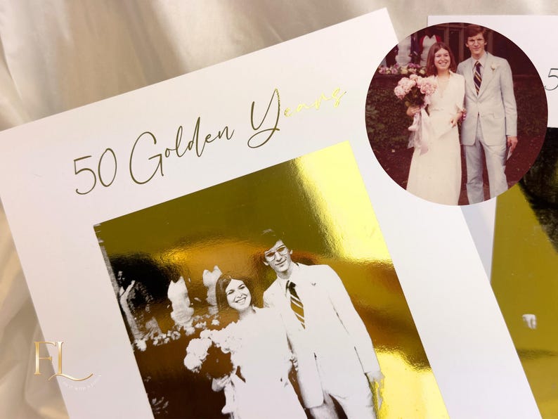 May include: A white card with gold foil accents and the text "50 Golden Years" in elegant script. The card features a black and white photo of a couple, with a circular photo of the couple in the upper right corner. The card is a wedding anniversary theme.