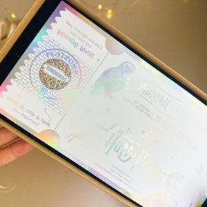 May include: A decorative box containing a holographic invitation with text that reads "Step through the wall and into the Wizarding World!" and "The Making of Harry Potter". The invitation features an owl illustration.