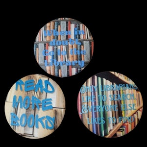 May include: Three round buttons with a bookshelf background and blue text. The first button says "When in doubt, go to the library". The second button says "Read more books". The third button says "Only librarians like to search, everyone else likes to find."