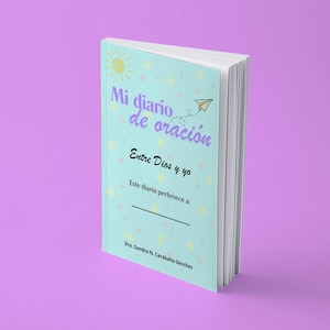 Puede incluir: Un diario de oración de color azul claro con tapa blanda que presenta un sol amarillo, pequeñas estrellas amarillas y un gráfico de avión de papel. El texto de la portada dice Mi diario de oración, Entre Dios y yo, Este diario pertenece a: y Dra. Sandra N. Caraballo-Sánchez.