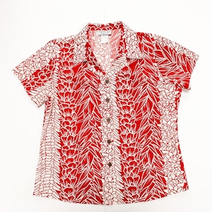 May include: A red and white short-sleeved button-down shirt with a floral print. The shirt has a collar and a button-up front.