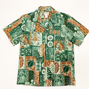 May include: A green and brown short-sleeved button-down shirt with a Hawaiian print featuring geometric patterns, tropical leaves, and turtles. The shirt has a white collar and a button closure.