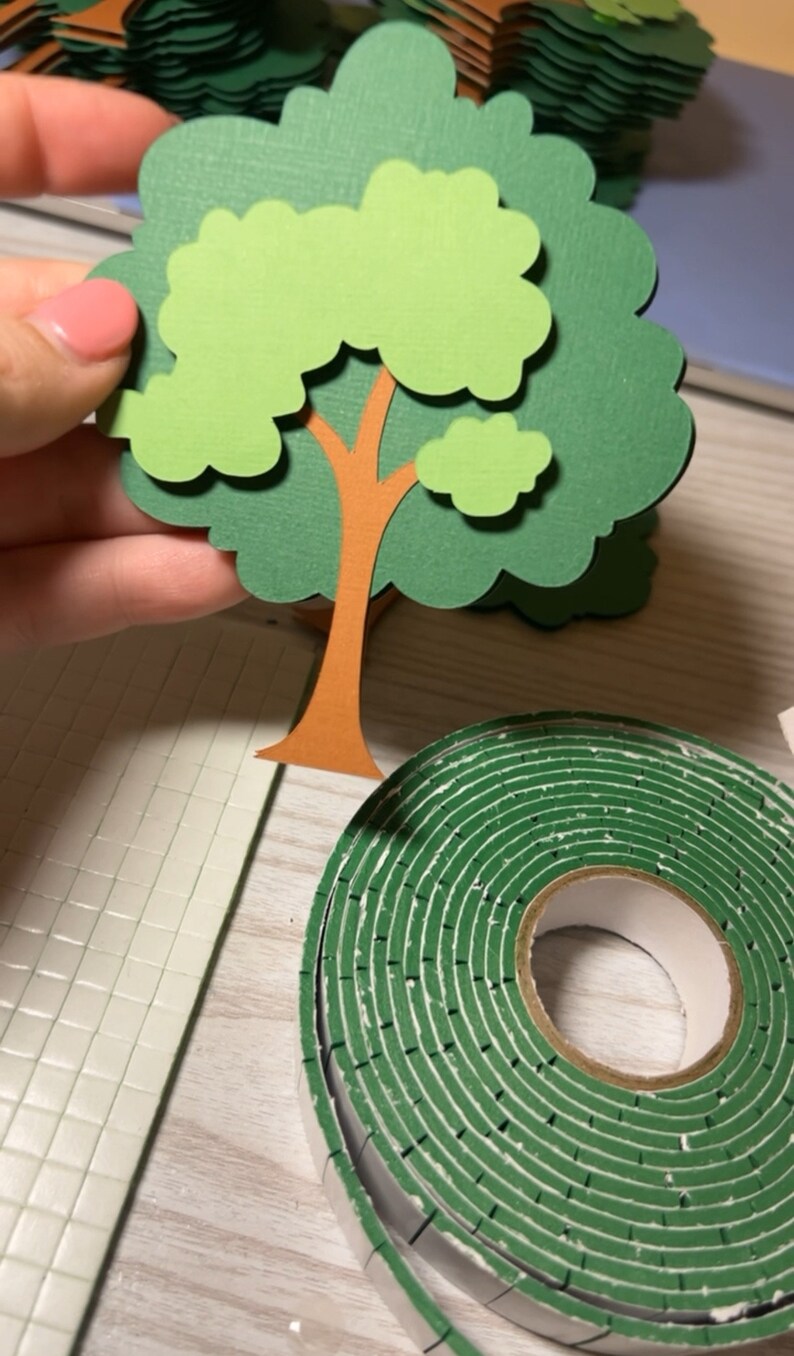 May include: A green paper craft tree with a brown trunk and a roll of green double-sided tape.
