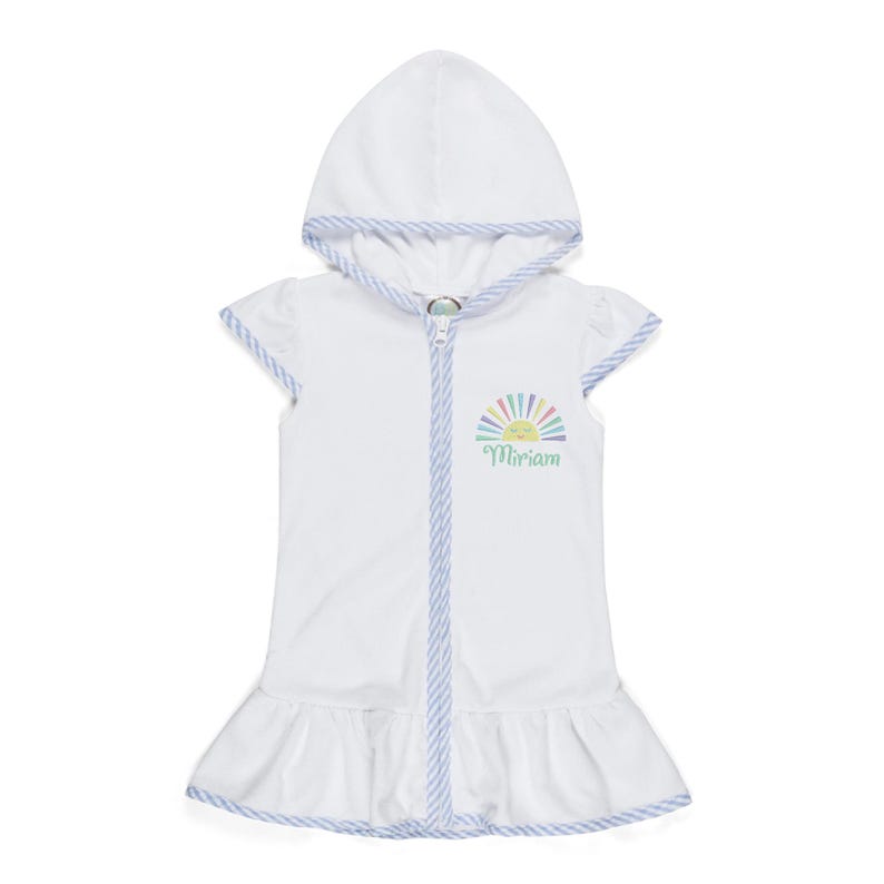 Peut inclure: Robe de plage blanche &agrave; capuche avec fermeture &eacute;clair et ourlet &agrave; volants. La robe pr&eacute;sente un motif de soleil color&eacute; et le nom "Miriam" en &eacute;criture cursive. Les bords sont bord&eacute;s d'un motif ray&eacute; bleu et blanc.