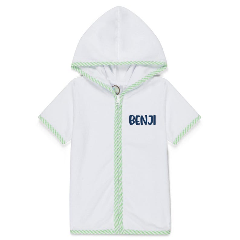Peut inclure: Robe blanche &agrave; capuche et manches courtes, bord&eacute;e de vert et ferm&eacute;e par une fermeture &eacute;clair. Le mot "BENJI" est imprim&eacute; en bleu marine sur le devant. Fabriqu&eacute; dans une mati&egrave;re douce et absorbante.