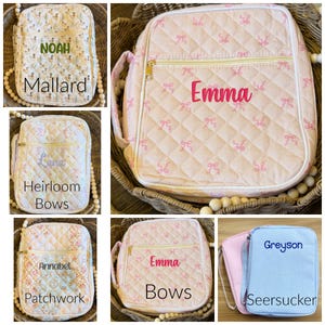 May include: Collection of quilted bags in various patterns and colors. One bag features a duck pattern with "Noah" and "Mallard" text. Another has pink bows and "Emma" embroidered. Other bags include floral, bow, and seersucker designs with names.