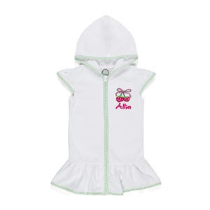 Peut inclure: Robe de b&eacute;b&eacute; blanche &agrave; capuche avec fermeture &eacute;clair et ourlet &agrave; volants. La robe pr&eacute;sente une bordure verte et un motif de cerises avec le nom "Allie" brod&eacute; en rose.