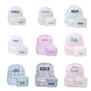 May include: Nine personalized backpack and lunch bag sets. The backpacks feature names like "Walker," "Annabelle," and "Benji" in various fonts and colors. The sets have different patterns, including stripes, floral, and construction vehicles.