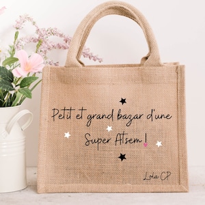 May include: A brown burlap tote bag with black and white stars and the text "Petit et grand bazar d'une Super Atsem!" and "Lola CP" in black text.