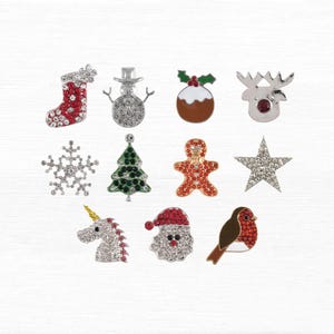 May include: A selection of Christmas-themed rhinestone brooches. Designs include a stocking, snowman, Christmas pudding, reindeer, snowflake, Christmas tree, gingerbread man, star, unicorn, Santa, and robin.