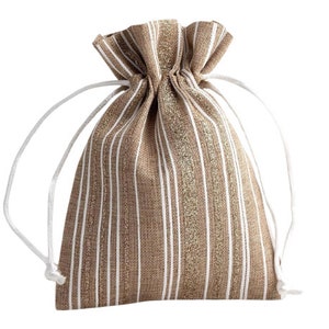 Pode incluir: Uma bolsa de cordão marrom e branca listrada com detalhes de glitter dourado. A bolsa é feita de um material de tecido e tem um cordão branco.