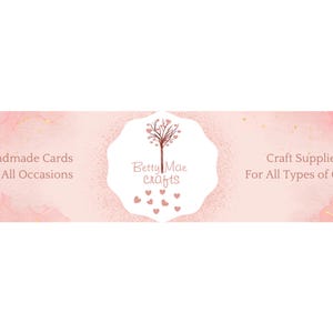 Peut inclure: Banni&egrave;re rose et or avec le texte "Cartes faites main pour toutes les occasions" &agrave; gauche, "Betty Mae crafts" au centre avec un arbre rose et des c&oelig;urs, et "Fournitures artisanales pour tous types d'artisanat" &agrave; droite.
