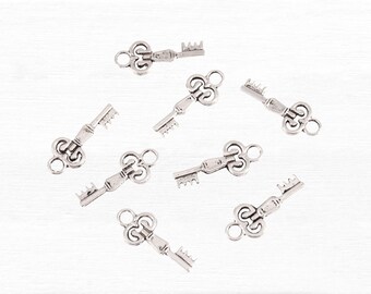 May include: Eight silver-toned key charms with intricate designs. The keys have a decorative, ornate, and vintage style.