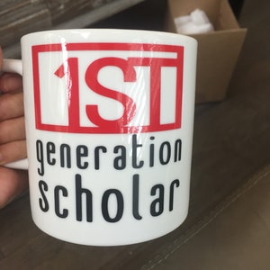 May include: White ceramic mug with a red square and the text "1ST generation scholar" in black.