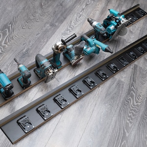 Puede incluir: Dos organizadores de herramientas negros con varias herramientas eléctricas turquesas y negras. Las herramientas incluyen una pistola de calor, un taladro, una sierra de calar, una amoladora y una sierra circular. Los organizadores tienen ranuras para baterías.