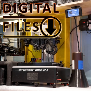May include: A black 3D printer with a yellow frame and a black resin print on the platform. The printer is labelled "ANYCUBIC PHOTON M3 MAX".