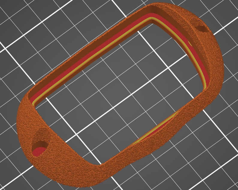 May include: A brown leather key fob with a red and yellow trim. The fob has a keyhole on the side.