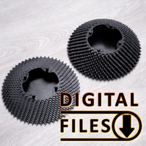 Puede incluir: Dos objetos circulares negros con una superficie texturizada y puntiaguda. Los objetos tienen una abertura central y están colocados sobre un fondo claro de vetas de madera. Las palabras "DIGITAL FILES" se muestran en naranja y blanco con una flecha hacia abajo.