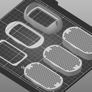 May include: Five 3D printed objects on a black grid surface. Two are rectangular frames, one is a rounded frame, and two are oval-shaped with a honeycomb pattern.