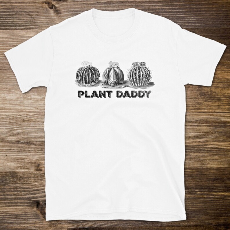 May include: White t-shirt with a black and white illustration of three cacti and the text "PLANT DADDY" printed on the front.