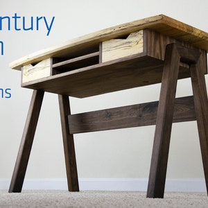 May include: Mid-Century Modern Desk project plans. A wooden desk with a light wood top and dark wood legs. The desk has two drawers and a shelf.