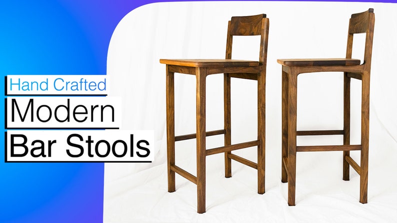 May include: Two hand-crafted modern bar stools made of dark wood. The stools have a simple design with a rectangular seat and a back rest.