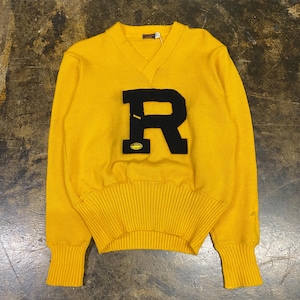 May include: A bright yellow V-neck sweater featuring a large, black felt letter R appliqué on the chest. The letter R includes a small, embroidered yellow football graphic at the bottom. The sweater has long sleeves with ribbed cuffs and a wide ribbed hem.