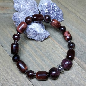 May include: A bracelet made with red tiger's eye and garnet beads with silver accents.