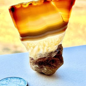 Lámina de ágata pulida montada sobre una piedra de río ornamentada. Hecha a mano. ¡Pieza única!