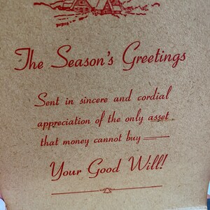 May include: A vintage greeting card with the text "The Season's Greetings" in red script. The card features a red illustration of a cabin in the mountains. The message continues with "Sent in sincere and cordial appreciation of the only asset that money cannot buy - Your Good Will!"