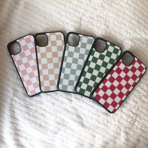 May include: Five different phone cases with a checkered pattern. The cases are pink, beige, grey, green, and red.