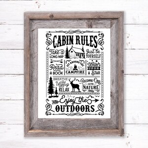 Op de afbeelding: Zwart-witte printbare poster met de tekst "Cabin Rules" en een lijst met regels om van de buitenlucht te genieten, waaronder "Neem een ​​lange dutje", "Lees een boek", "Zit rond het kampvuur", "Wens op een ster", "Adem in & haal de stekker eruit", "Ontspan", "Word één met de natuur", en "Geniet van de buitenlucht".