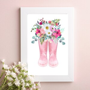 K&ouml;nnte beinhalten: Ein Aquarellbild von rosa Gummistiefeln mit einem Strau&szlig; rosa, wei&szlig;er und lila Blumen in den Stiefeln.