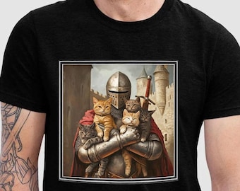 May include: Black t-shirt featuring a framed image of a knight in silver armor holding several cats. The knight is set against a backdrop of a castle and a red cape. The cats are various colors, including orange, gray, and brown.