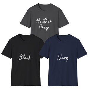 May include: Three short-sleeved crew neck t-shirts in heather grey, black, and navy blue. The heather grey shirt features the white text "Heather Grey," the black shirt features the white text "Black," and the navy shirt features the white text "Navy."